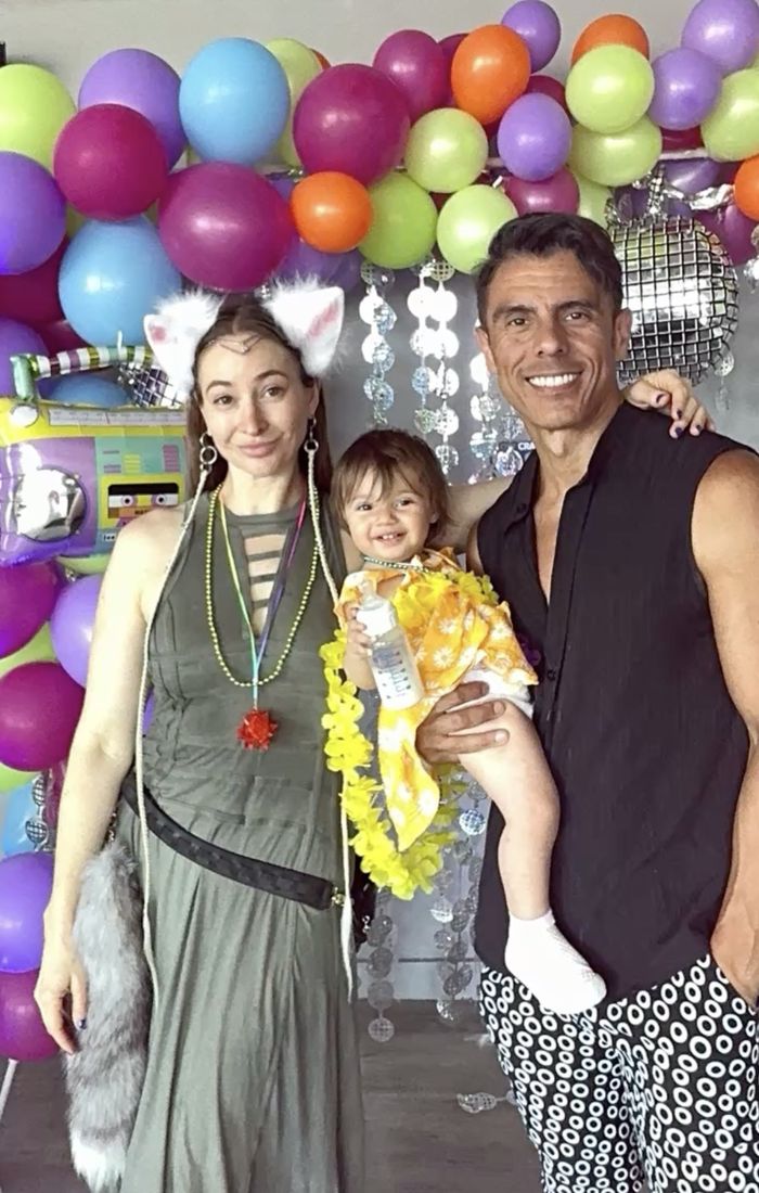 A mom and dad with their smiling toddler