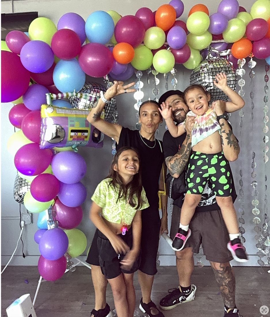A dad with his son on his shoulders and their family cheering