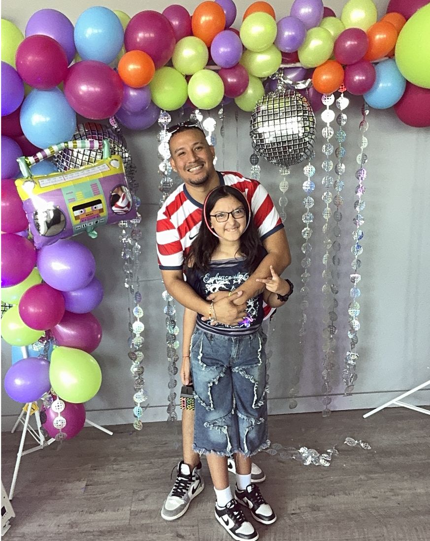 A dad hugging his smiling daughter