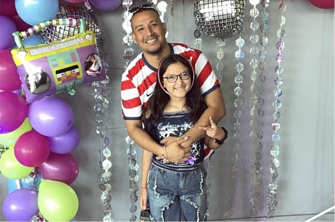 A dad and daughter smiling together