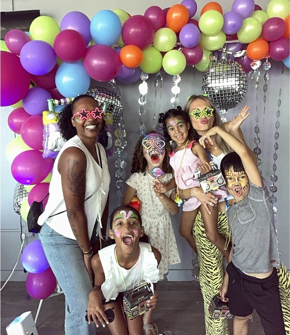 Two moms and five kids making silly faces at the photo booth